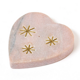 Heart-shaped stone with gold star designs on a white background