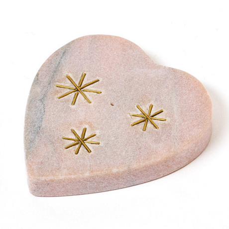 Heart-shaped stone with gold star designs on a white background