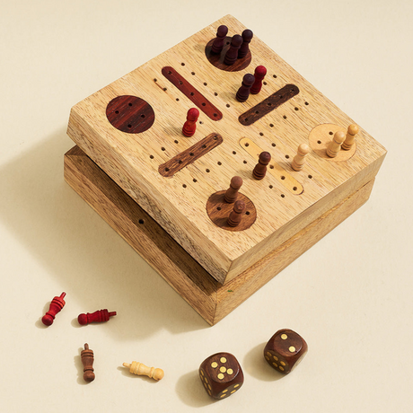 Wooden game board with pieces and dice on a beige background