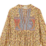 Yellow floral and paisley patterned blouse on a white background