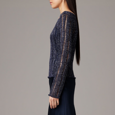 Woman wearing a dark blue textured sweater against a gray background