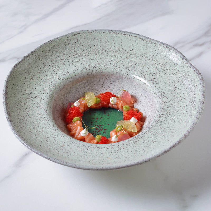 Dessert dish with fruit salad on a speckled ceramic plate