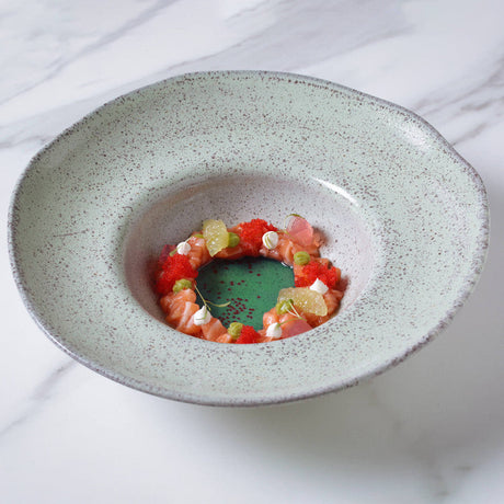 Dessert dish with fruit salad on a speckled ceramic plate