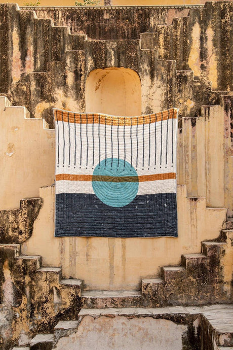 Textile with geometric pattern draped over a door in an old building setting