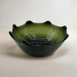 Green glass bowl with black rim on a white background