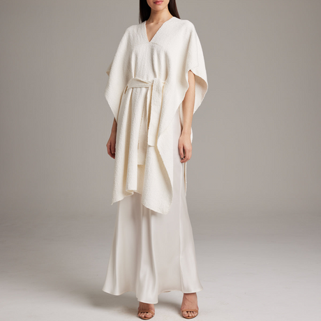 Woman wearing a white dress with a plain background