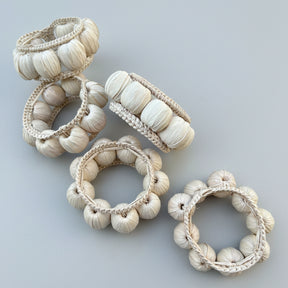 Set of decorative napkin rings with braided designs on a white background