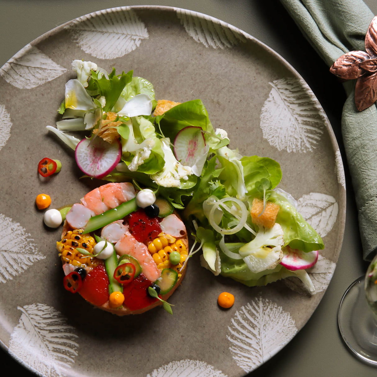 Gourmet salad with shrimp and vegetables on a decorative plate