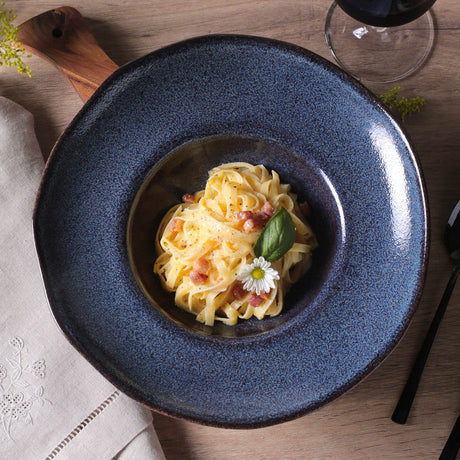 Blue ceramic plate with pasta dish on a wooden table