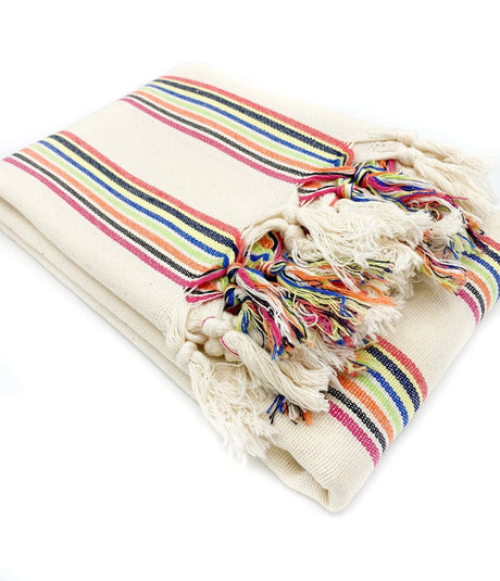Beige blanket with colorful striped pattern and tassels on a white background