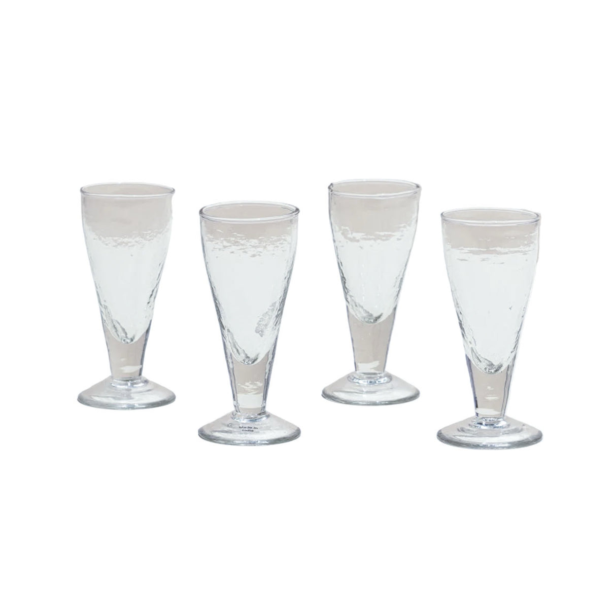 Four clear glass tumblers on a white background