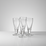 Set of four clear glass flutes on a light gray background