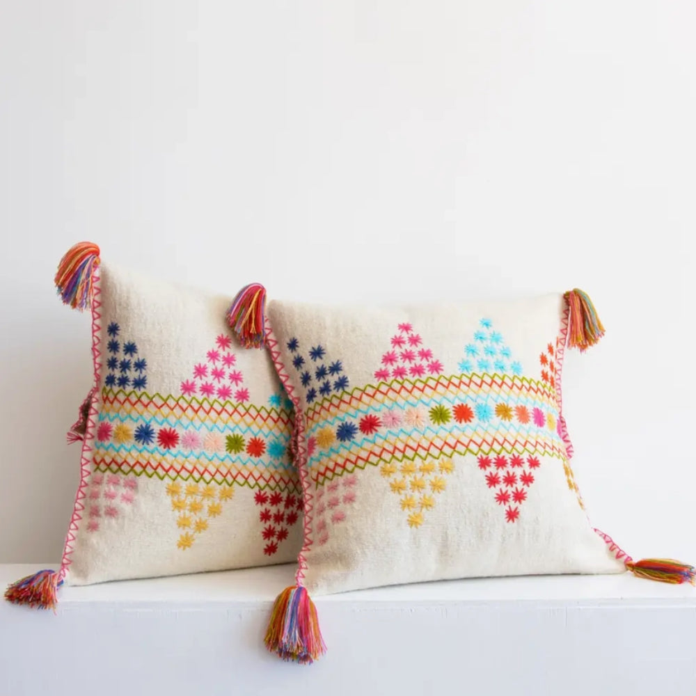 Decorative pillows with colorful patterns and tassels on a white background