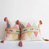 Decorative pillows with colorful patterns and tassels on a white background