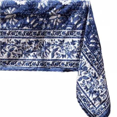Table set with a blue and white patterned tablecloth on a white background