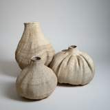 Three woven vases of different sizes on a light gray background