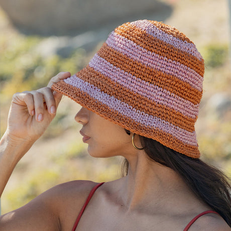 Woman wearing a striped bucket hat in a natural setting