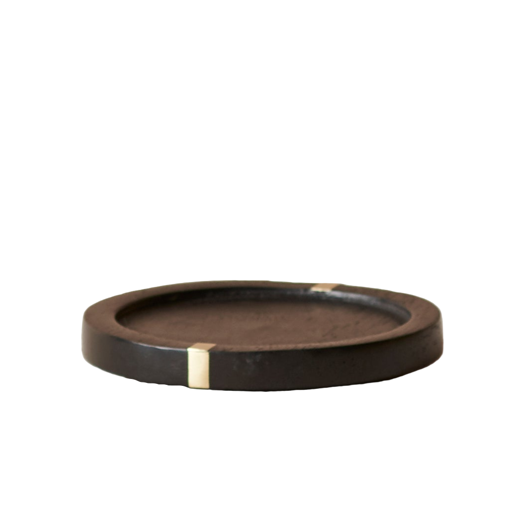 Round brown coaster with gold accent on a white background