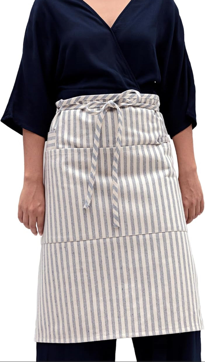 Person wearing a navy top and striped apron on a white background
