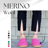 Person wearing pink slip-on shoes with 'Merino Wool' text and color swatches on a light background.