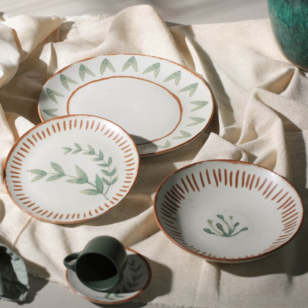 Set of ceramic plates with decorative patterns on a light fabric background