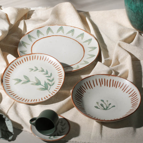 Set of ceramic plates with decorative patterns on a light fabric background