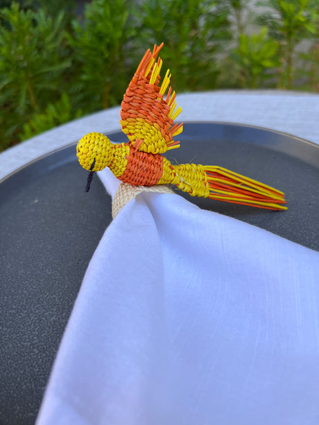 Close-up of a yellow and orange decorative item on a white surface with a blurred green background