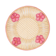 Round woven plate with pink floral designs on a white background