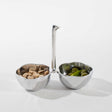 Silver two-compartment bowl with a spoon on a white background