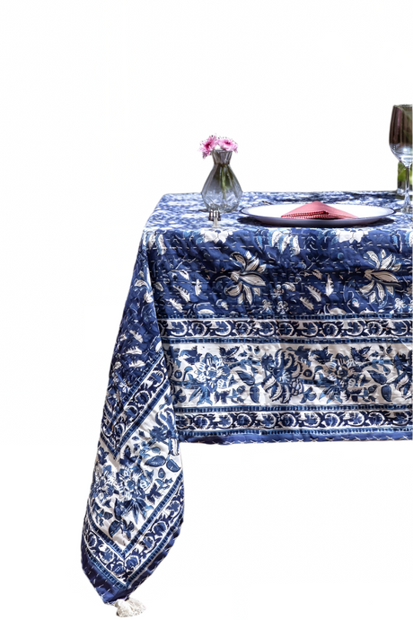 Table set with a blue and white patterned tablecloth on a white background