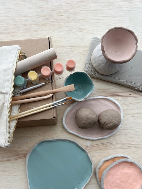 Clay modeling tools and materials on a wooden surface