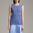 Woman wearing a blue sleeveless top with a textured pattern on a gray background