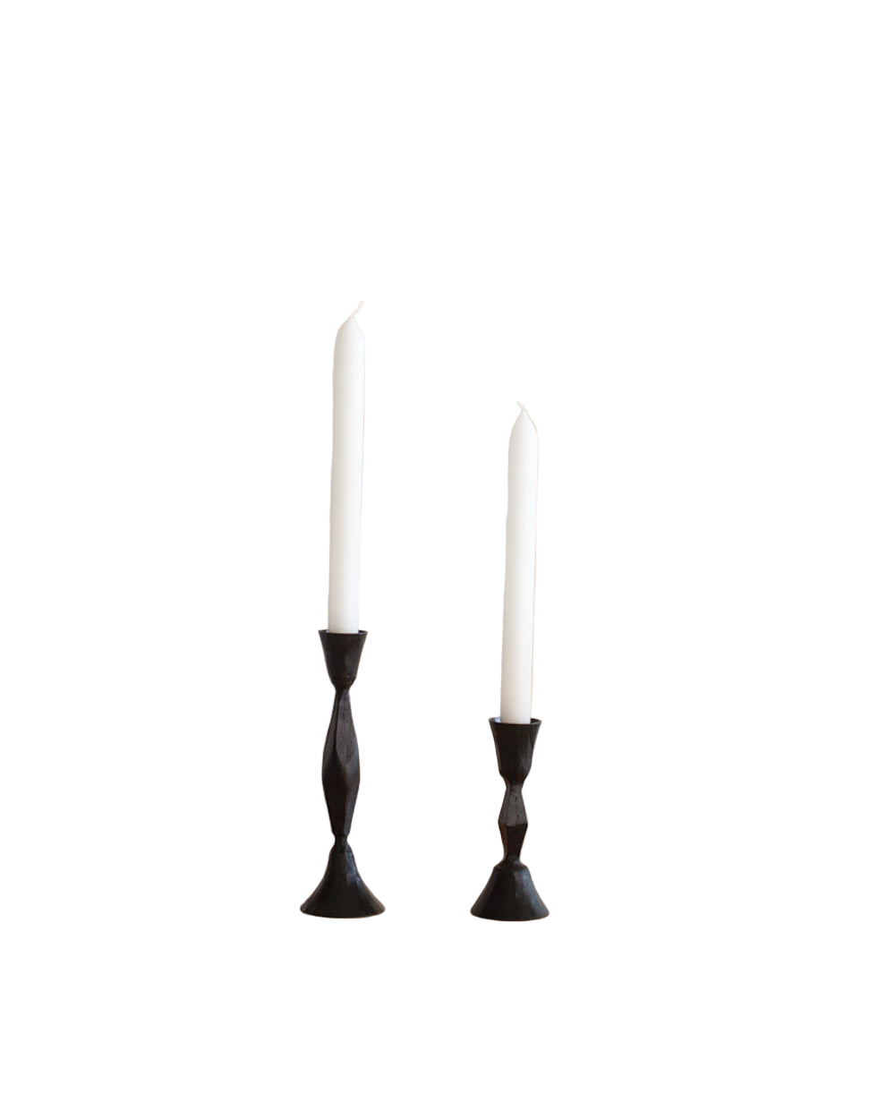 Two white candles in black candle holders on a white background