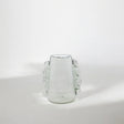 Clear glass vase with decorative tassels on a white background