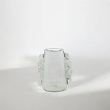 Clear glass vase with decorative tassels on a white background