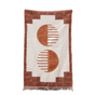 Rug with geometric pattern draped over a chair against a warm-toned wall.