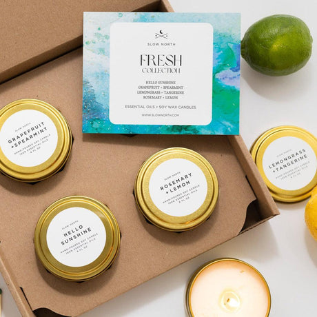 Collection of soy wax candles with gold lids and labels, displayed on a white surface with a 'Fresh Collection' card above.