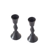 Two black candle holders on a white background