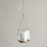 Hanging glass lantern with candle inside on a plain background