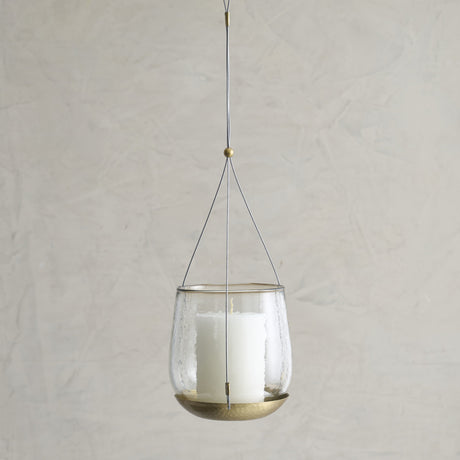 Hanging glass lantern with candle inside on a plain background