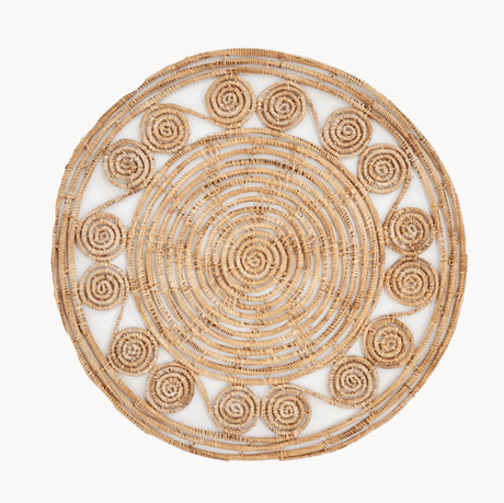 Round woven placemat with concentric circle pattern on a white background