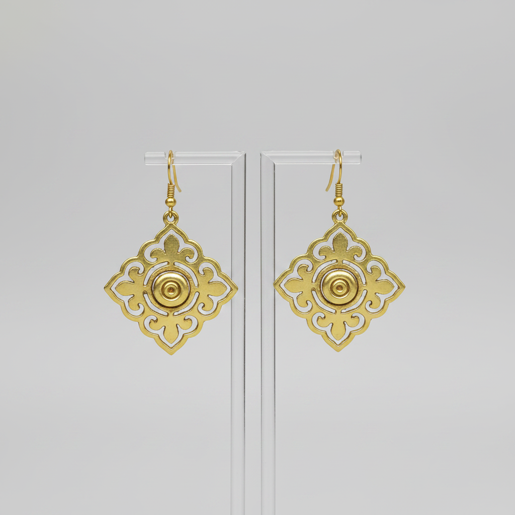 Gold earrings with intricate designs on a light gray background
