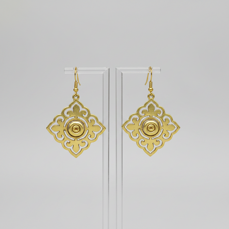 Gold earrings with intricate designs on a light gray background