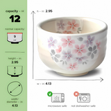 The Kohiki Pink Sakura Ceramic Matcha Bowl, adorned with a pink floral design, holds 12 oz. It's perfect for traditional matcha tea ceremonies and is microwave safe but not dishwasher safe. Pair it with a bamboo whisk for an authentic experience. Dimensions are included.