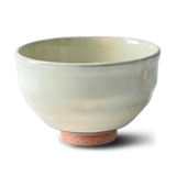 The White Kohiki Ceramic Matcha Bowl, featuring a light green glaze and textured brown base, crafted using Minoyaki pottery techniques, rests elegantly on a white background.