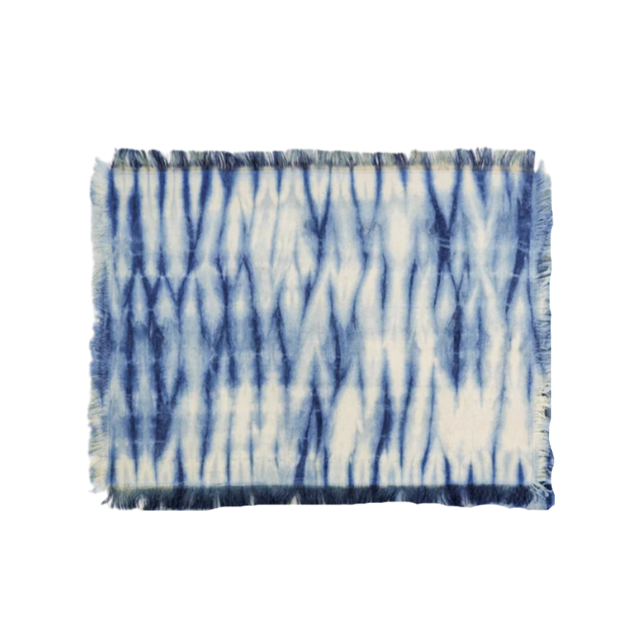 Set of blue and white tie-dye placemats on a white background