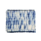 Set of blue and white tie-dye placemats on a white background