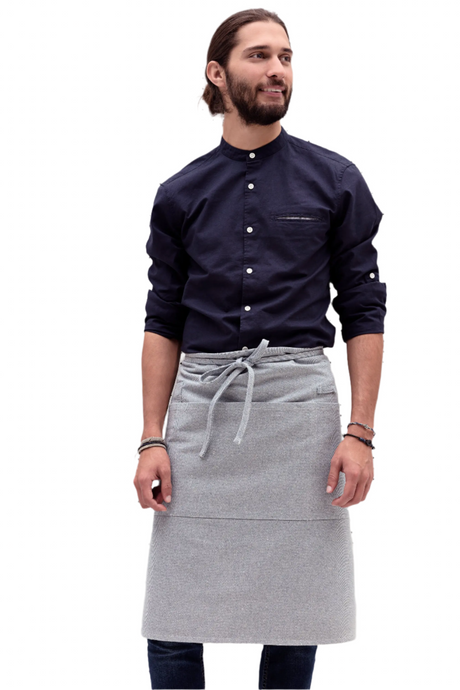 Man wearing a navy shirt and gray apron on a white background