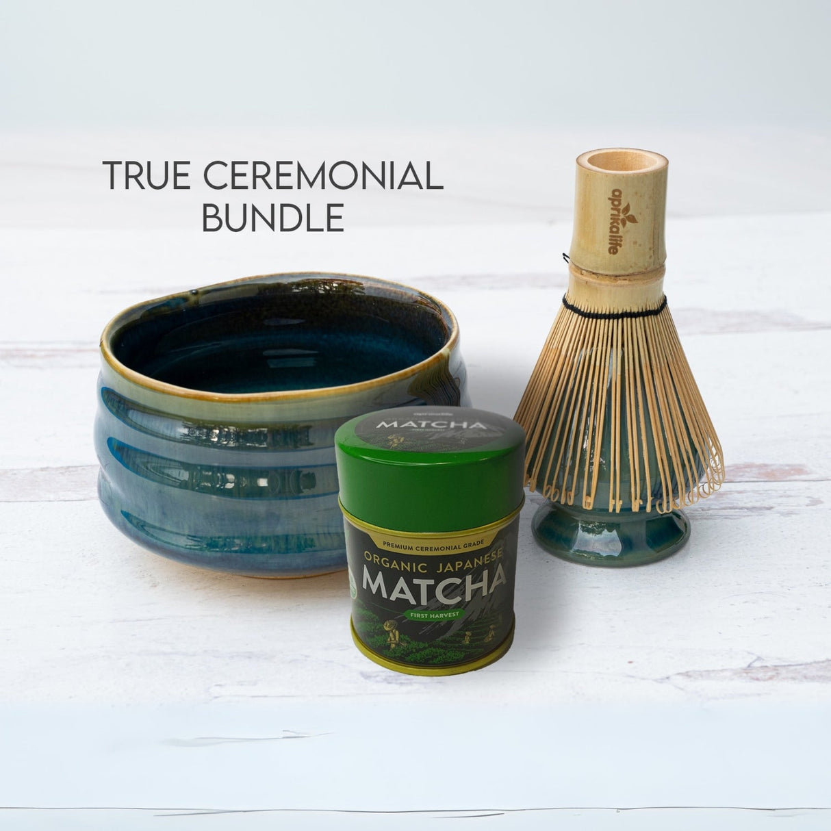 The "Blue Ceramic Matcha Bowl, Bamboo Matcha Whisk, Whisk Holder and Organic Japanese Matcha Set" enhances the white surface with elegance.