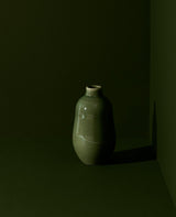 Green ceramic vase on a dark background